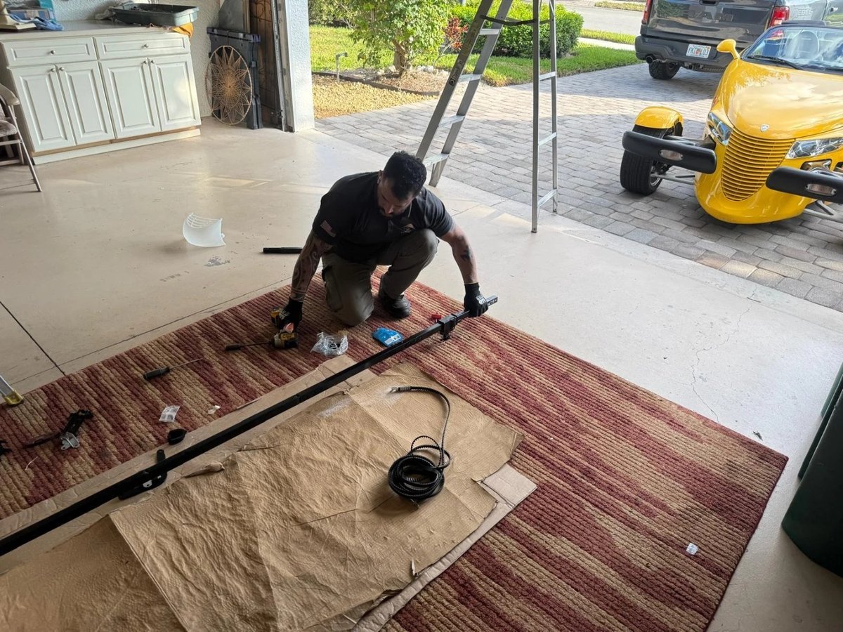 Spring shaft and tools laid on a rug while a worker assembles hardware