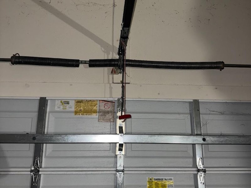 Torsion shaft and center mounting plate above a closed steel door